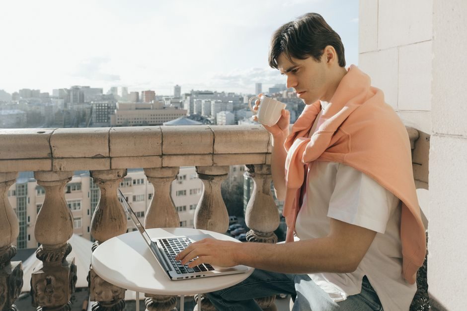 How to work on fiverr — Freelancer Working On Laptop With Cityscape Background - image 2